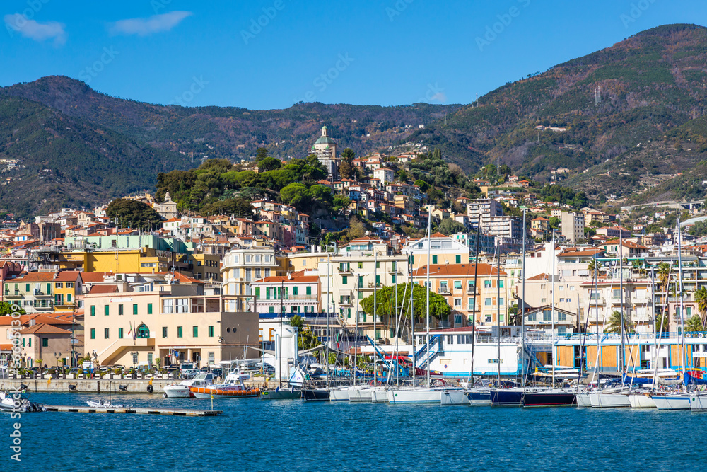 Sanremo, Italy,  day view from the sea with boats and yachts to the old town of Sanremo (La Pigna) and Madonna della Costa Church on the hilltop, Liguria, Italy