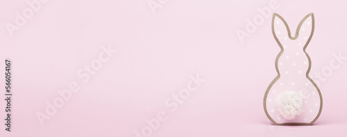 Decorative pale pink Easter bunnies isolated on a background of bright yellow paper. A family of rabbits, a mother and two children. Minimal family Easter concept. Happy Easter symbol.
