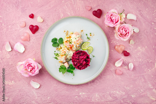 Traditionell gedämpfter und gewürfelter Lachsfilet Salat auf Apfel Scheiben mit Rote Bete Relish serviert als Draufsicht auf einem Nordic Design Teller