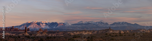 Panorama of rock formations with distant snow-covered mountains in the distance in Arches National Park.