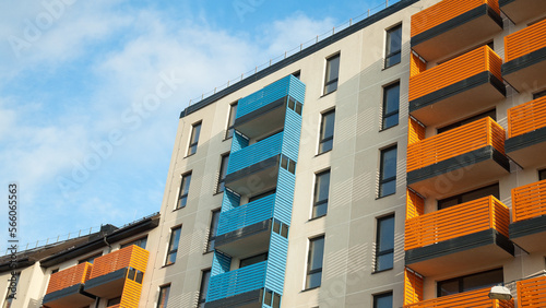 facade of the building with multi-colored balconies against the blue sky © fotofotofoto