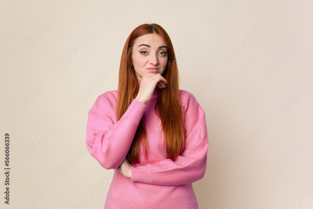 Young red hair woman isolated suspicious, uncertain, examining you. Young red hair woman isolated suspicious, uncertain, examining you.
