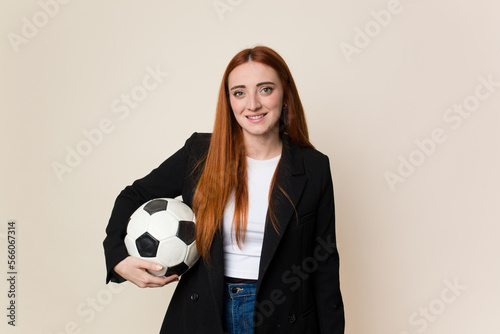 Young soccer trainer woman holding a soccer ball isolated © Asier