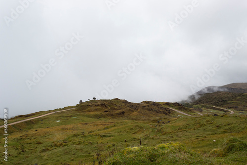 Beautiful colombian paramo landscape with sand road grass mountains and fog © Alejandro Bernal