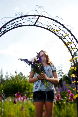 Wallpaper Mural A teenage girl standing under an arch holding freshly picked flowers from a organic garden in Idaho. Torontodigital.ca