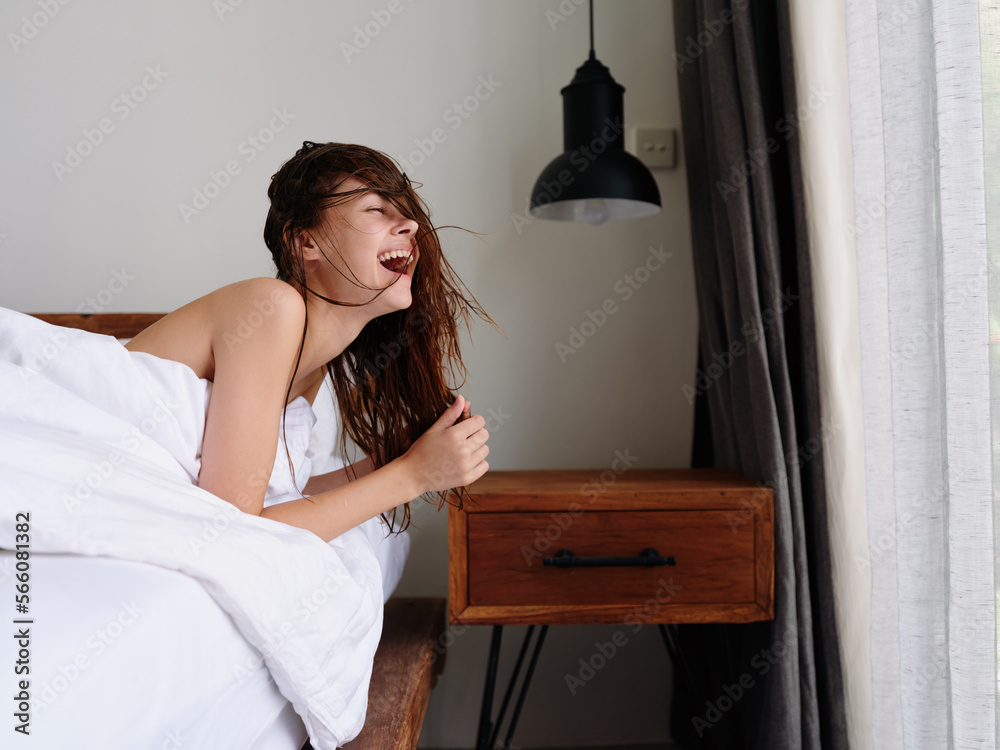 A woman after a shower lies on a bed in a bedroom near a window with wet hair, a healthy sleep on an orthopedic patras and a pillow with a memory effect A woman after a shower lies on a bed in a bedroom near a window with wet hair, a healthy sleep on an orthopedic patras and a pillow with a memory effect