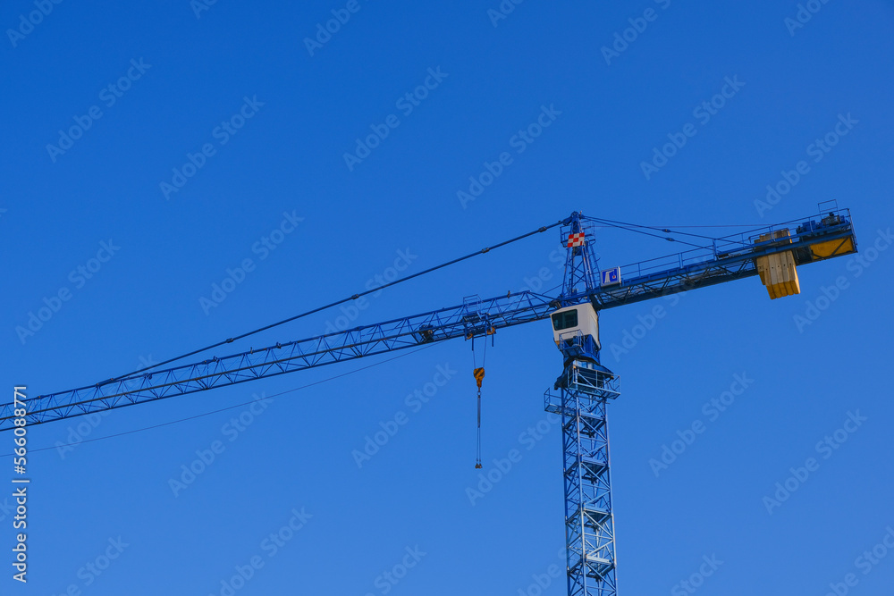 Building concept. Construction cranes on blue sky background.New house construction.