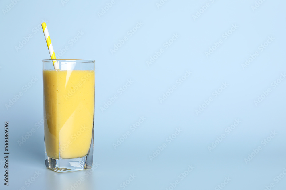 Glass of tasty smoothie with straw on light blue background. Space for text Glass of tasty smoothie with straw on light blue background. Space for text