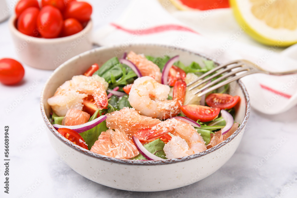 Delicious pomelo salad with shrimps served on white marble table, closeup