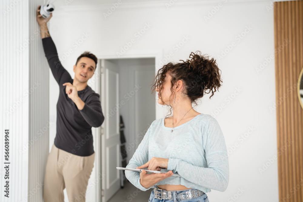 Fototapeta premium man and woman couple wife husband set up surveillance security camera