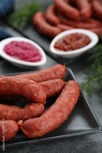 Tasty sausages served on black table, closeup. Meat product