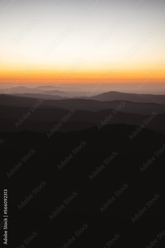 Vertical view of beautiful layers of mountains with golden light after sunset in Las Villuercas, Cáceres, Extremadura, Spain