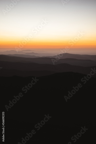 Vertical view of beautiful layers of mountains with golden light after sunset in Las Villuercas, Cáceres, Extremadura, Spain © Miguel