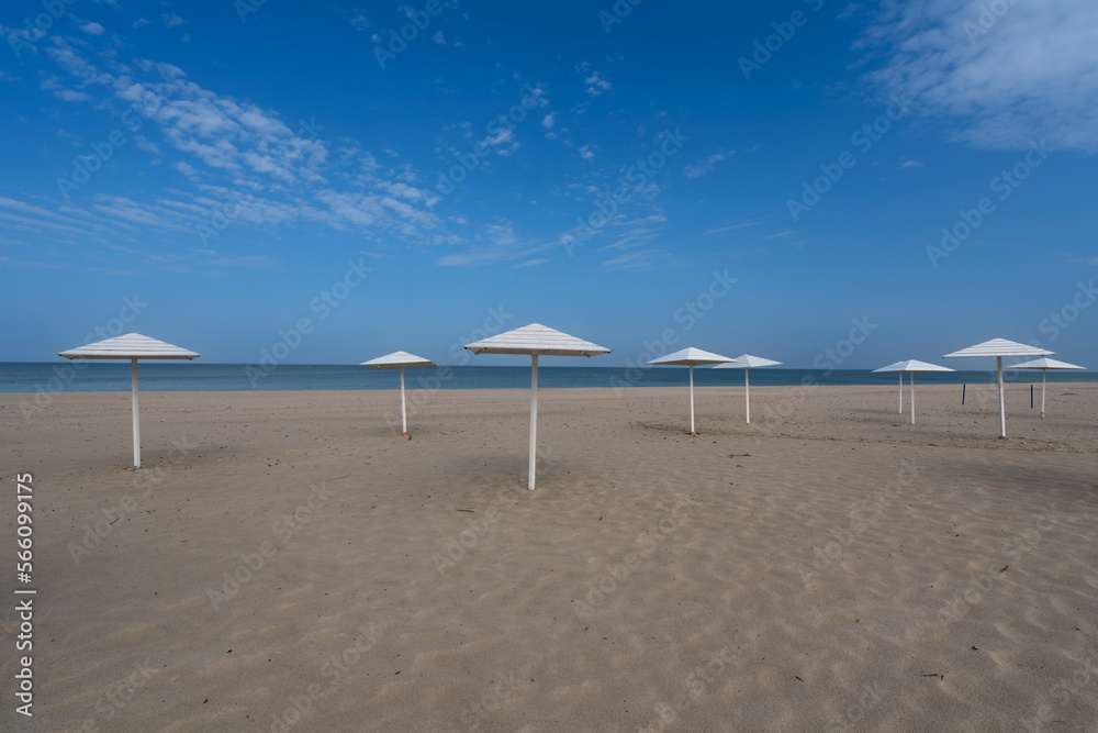 A deserted beach with wooden umbrellas on the shore of the Baltic Sea in the village of Yantarny, Kaliningrad region, Russia