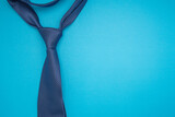 Top view of a necktie on a blue background with copy space for text