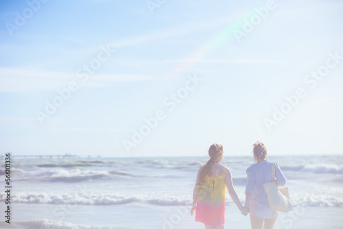 stylish mother and teenage daughter at beach relaxing