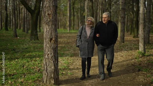 Slow-motion shot of a nice eldelry couple walking to their tent in the forest