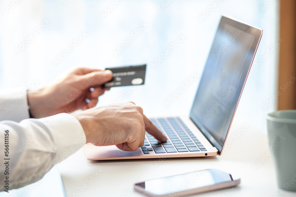 Purchases via the Internet and payment for services buy credit card. Hands type text and enter data on the laptop keyboard. An office worker checks his email while sitting at his desk