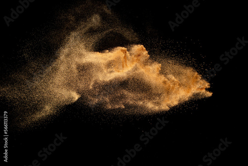 Dry river sand explosion. Brown colored sand splash against  black background.
