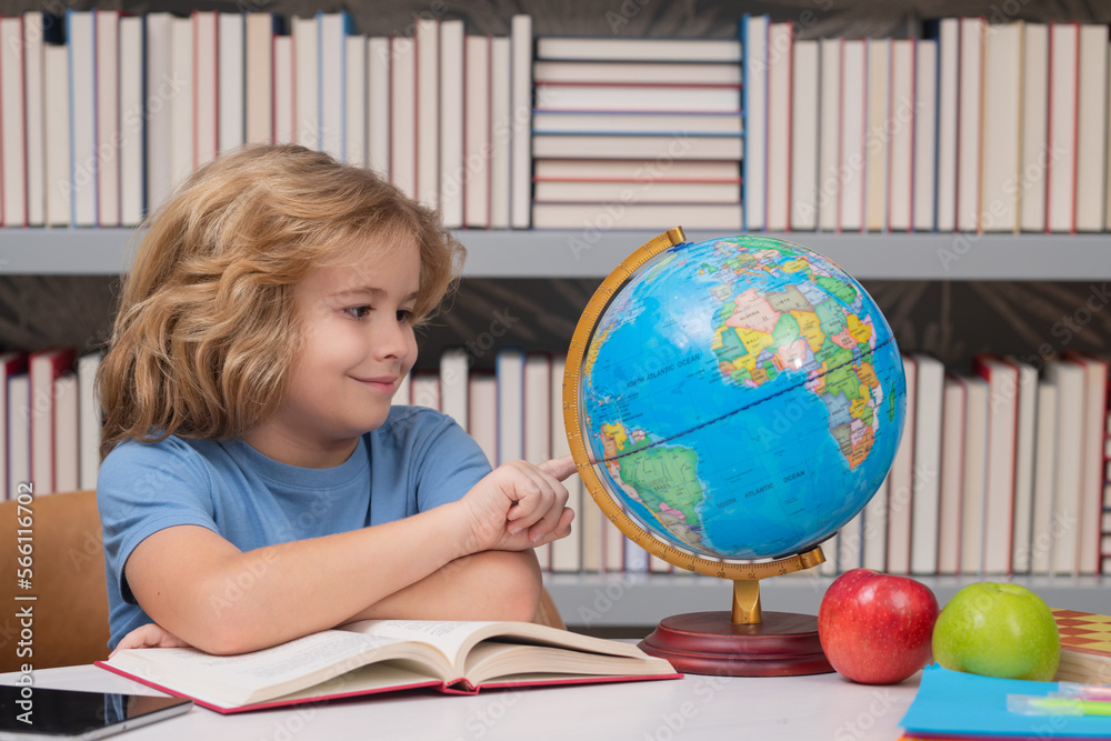 School kid pupil looking at globe in library at the elementary school. World globe. School kid 7-8 years old with book go back to school. Little student. Education concept. School kid pupil looking at globe in library at the elementary school. World globe. School kid 7-8 years old with book go back to school. Little student. Education concept.