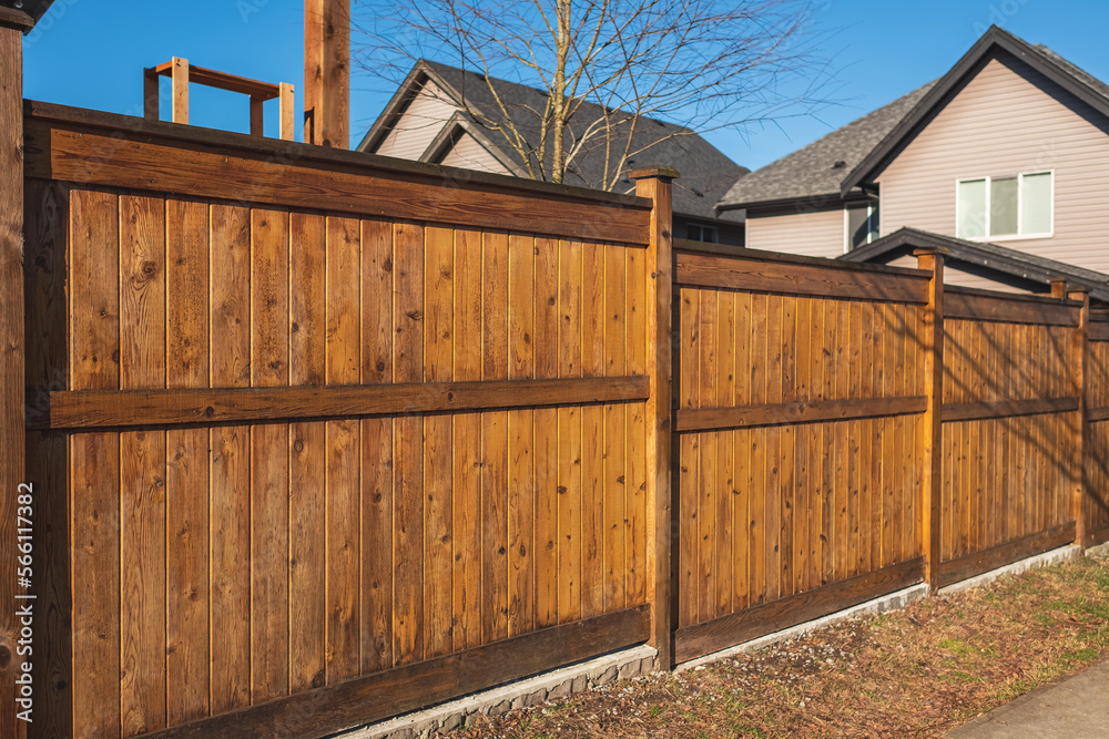 Nice wooden fence around house. Wooden fence with green lawn. Street photo Nice wooden fence around house. Wooden fence with green lawn. Street photo