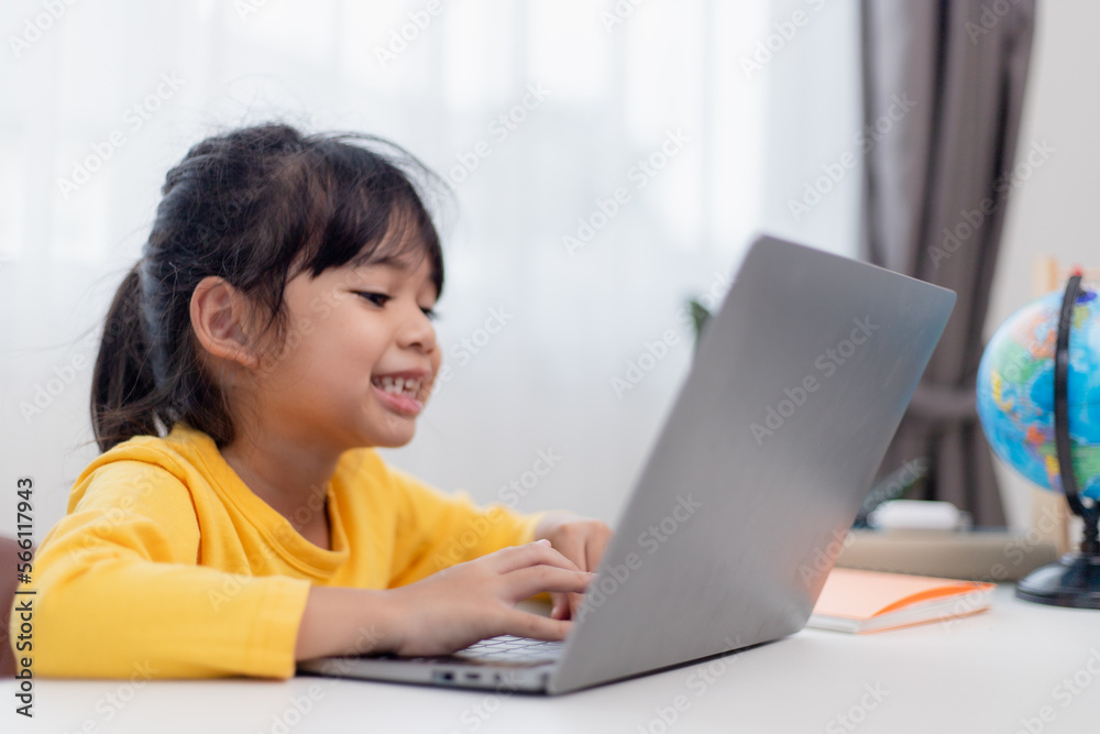 First day at school. Asian little girl using a laptop computer, studying through online e-learning system. First day at school. Asian little girl using a laptop computer, studying through online e-learning system.