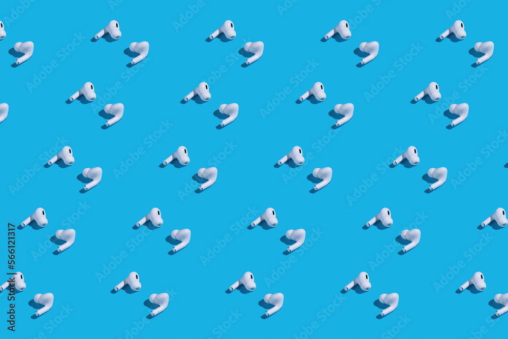 Rows of white earbuds on blue background Rows of white earbuds on blue background
