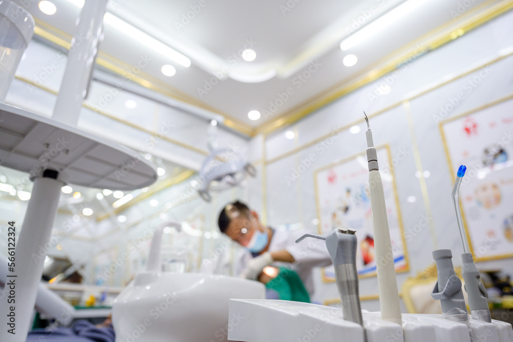 focus on medical equipment Orthodontist and assistant Dentist treating patient in dental chair in dental office Dentist blurred background