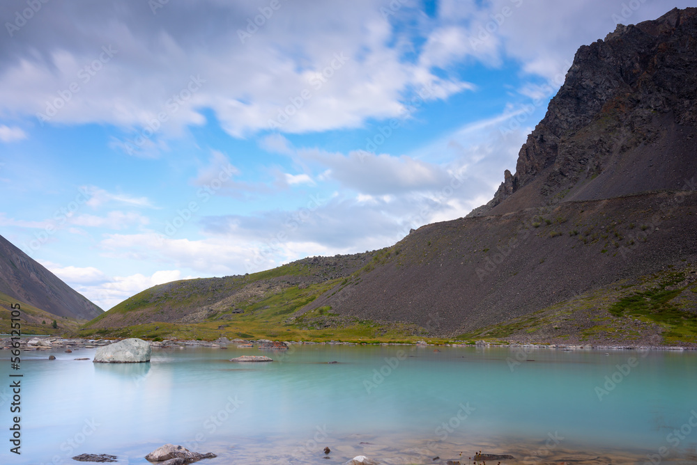 Mountain lake calm turquoise with clear water Karakabak in the Altai mountains under the clouds.