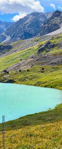 Panorama mountain lake calm turquoise with clear water Karakabak in the Altai mountains under thick clouds during the day. Vertical frame.