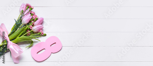 Bouquet of beautiful flowers and figure 8 on white wooden background with space for text. Women s Day celebration