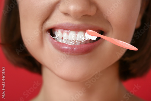Young woman with healthy teeth and brush on red background  closeup