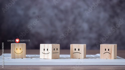 The best service, wooden blocks with symbol smile face and heart shape on keyboard. Great serivce customer satisfaction survey. An excellent rating for the quality of a service or product.. photo