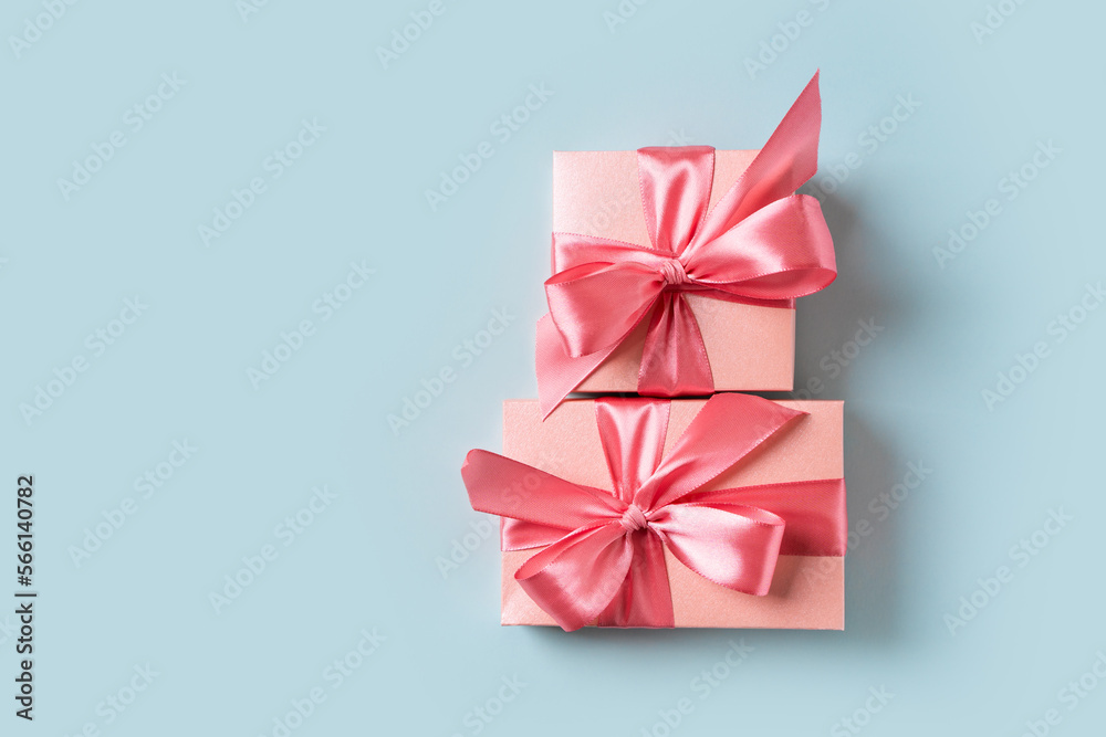 Pink gift box with bow on blue background Pink gift box with bow on blue background