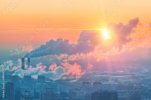 View of the city from the observation deck to skyscrapers in the setting sun and chimneys with smoke, Moscow City