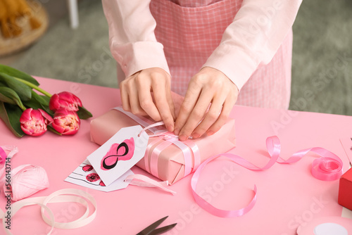 Woman making gift for International Women's Day celebration at table