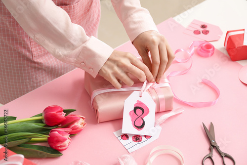 Woman making gift for International Women's Day celebration at table