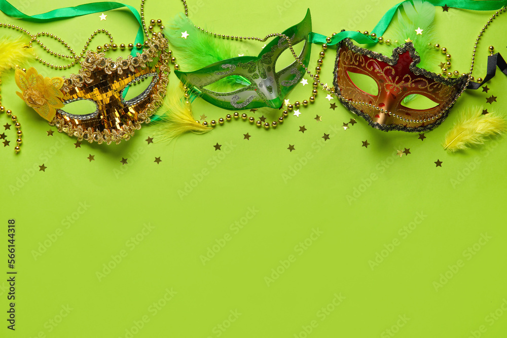 Fototapeta premium Carnival masks for Mardi Gras celebration with beads and stars on green background