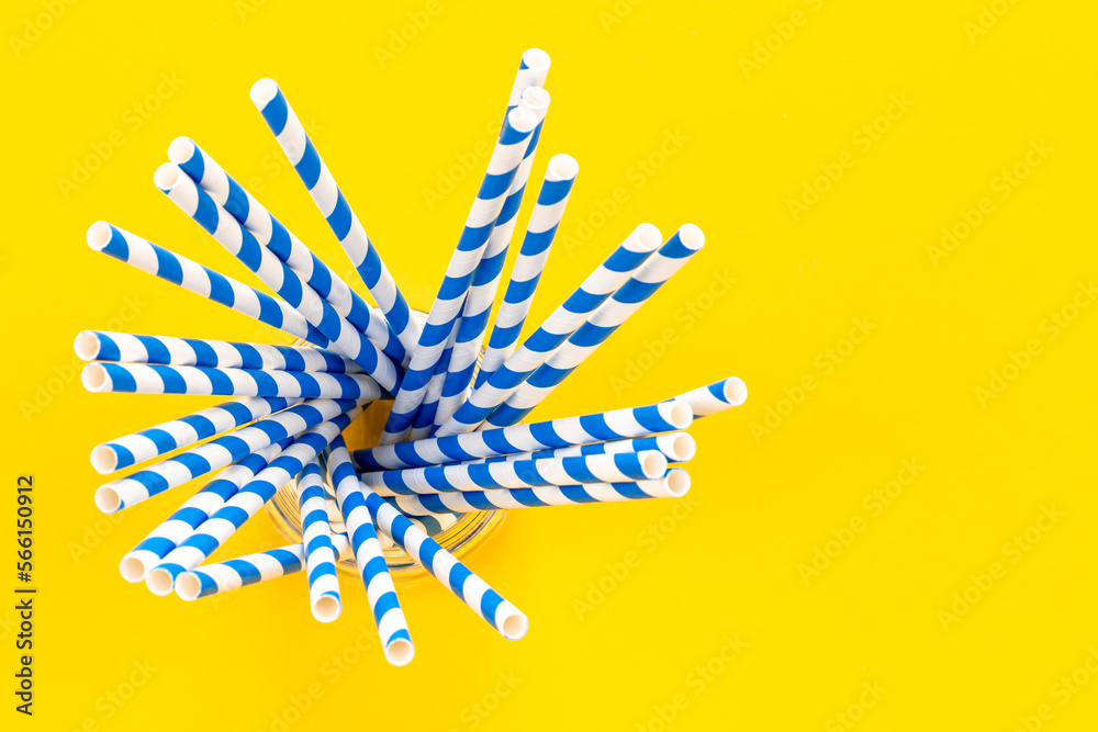 Paper straws for drinks on a yellow background, top view.