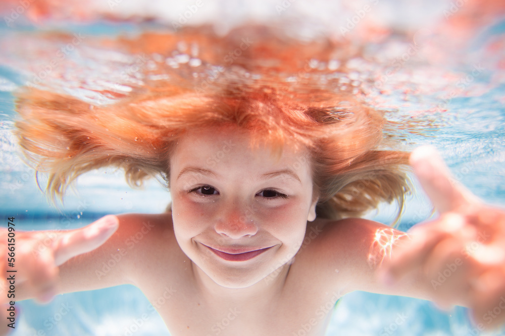 Funny kids face under water. Child swimming underwater in swimming pool