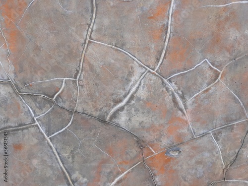Abstract cracked grey cement wall texture background with orange stain
