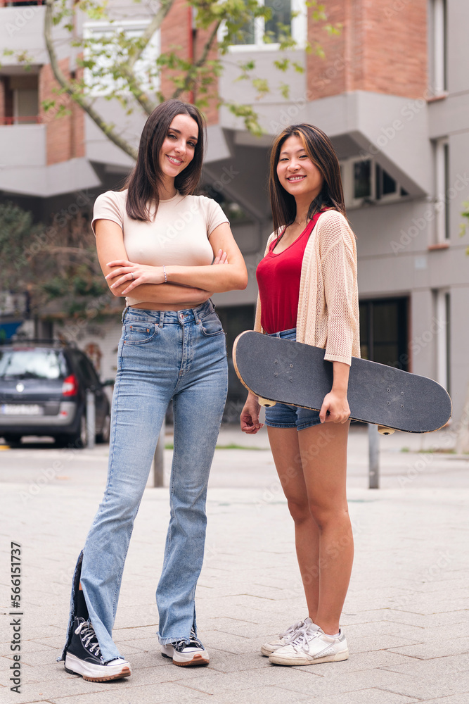vertical photo of two young women posing happy and smiling looking at camera, concept of female friendship and teenager lifestyle