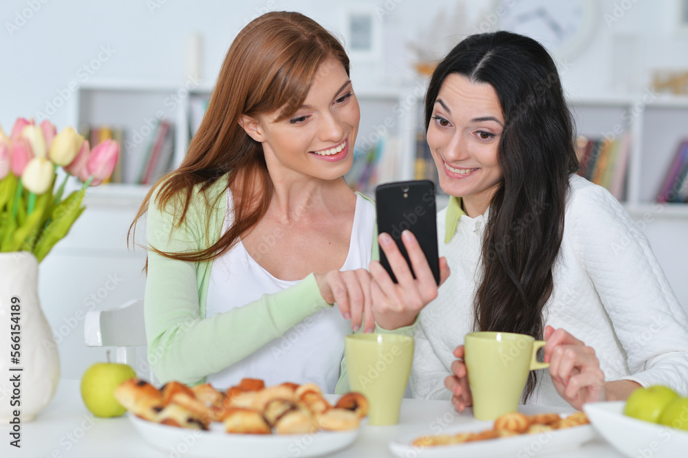 two female friends with modern smartphone