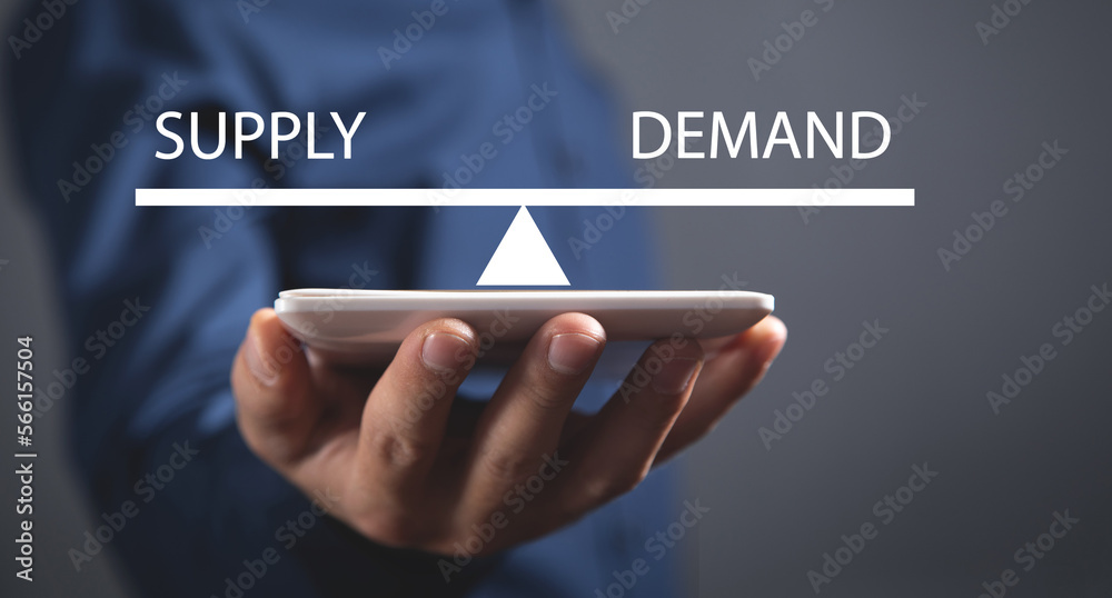 Man showing supply and demand word balance scales. Business concept