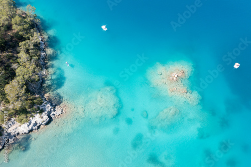 Aerial view on the blue lagoon with rocky coast, Turkey. Travel on sea board in sunny day. Beautiful coastline and sea near Oludeniz. 