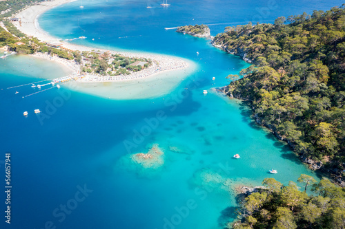 Aerial view on amazing landscape of blue sea and beach with white sand, colorful umbrellas and tourists. Sunny day in small town Oludeniz, Turkey. 