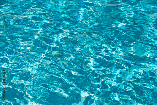 Background of blue water in swimming pool with sun reflection, ripple water wave in pool. Clear water background.