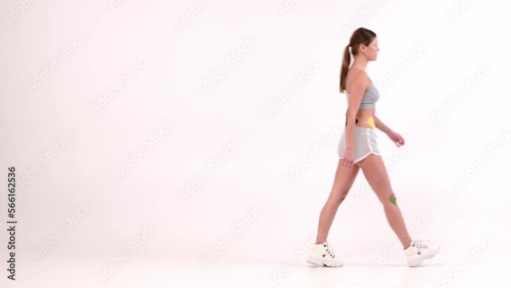 female athlete with kinesiotape on her body runing from left to right female athlete with kinesiotape on her body runing from left to right