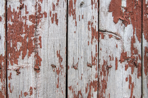 Old boards with remnants of red paint. Texture of the old wooden surface.