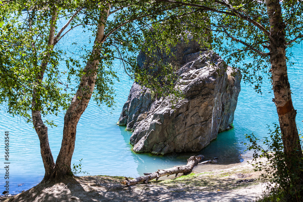 Stone block in the turquoise water of lake Issyk. Protected area of Kazakhstan